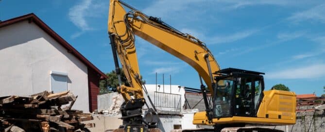 Backhoe Demolishing An Old House