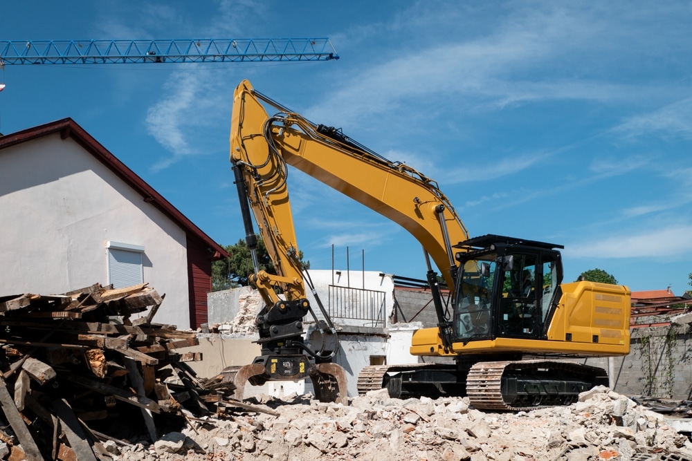 Backhoe Demolishing An Old House